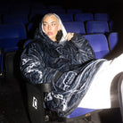 A lifestyle image of the Kraken-uggie on a female model sitting in a movie theatre