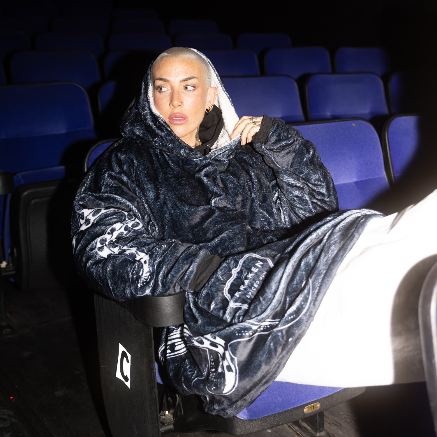 A lifestyle image of the Kraken-uggie on a female model sitting in a movie theatre