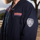 A side view lifestyle image of the Beware The Kraken Coveralls featuring the patches on a male model in the desert