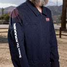 A side view lifestyle image of the Beware The Kraken Coveralls on a male model in the desert