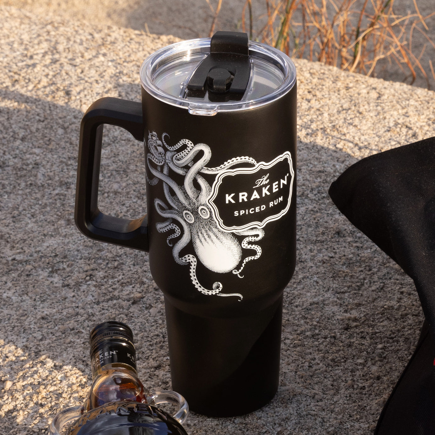 A lifestyle image of The Kraken tumbler on a boulder