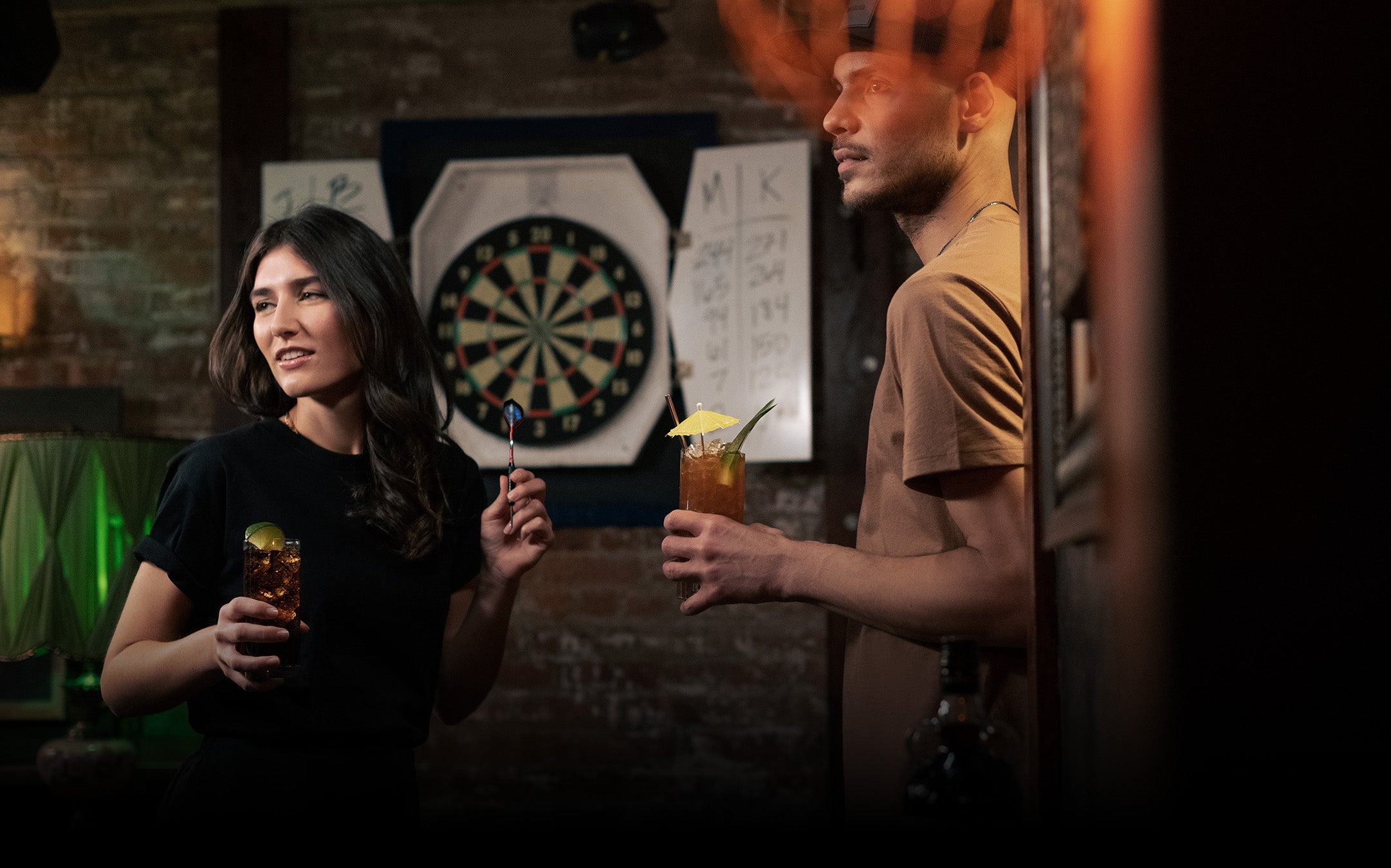 A Kraken bottle, glasses, and tiki mug displayed in front of Kraken wallpaper 