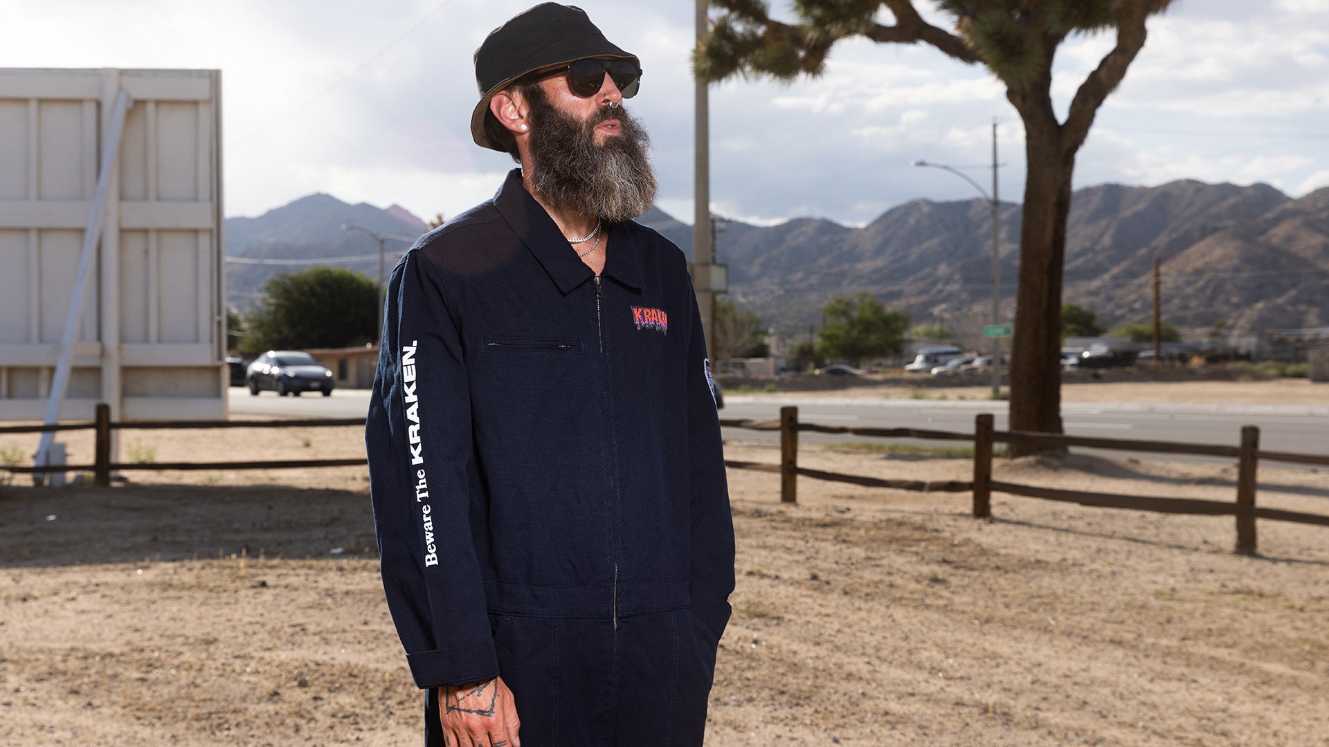 Lifestyle image of male model wearing the Beware The Kraken coveralls in the desert