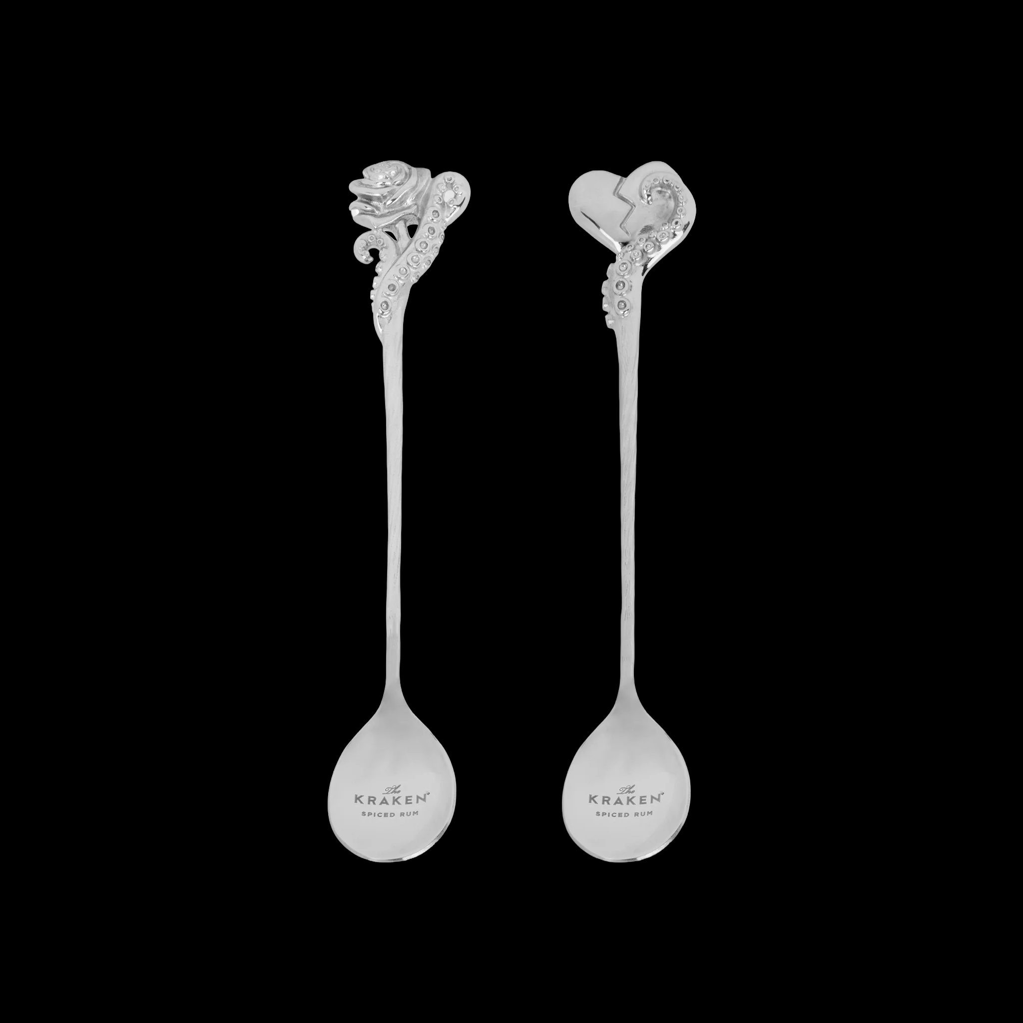 Two decorative cocktail spoons with rose and heart with tentacle designs on a black background