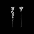 Two decorative cocktail picks with rose and heart with tentacle designs on a black background