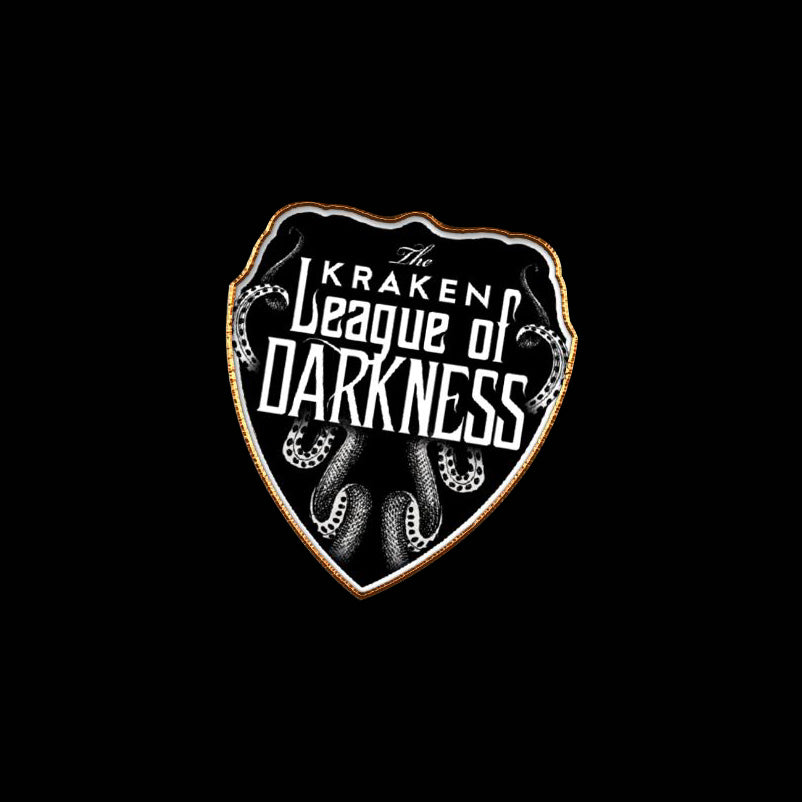 Pin resembling a shield with the text: "The Kraken League of Darkness," with a black background, white text, and a gold border.